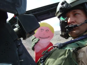 Pilot holding paper figure in cockpit.