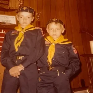 Two young scouts in uniform indoors.